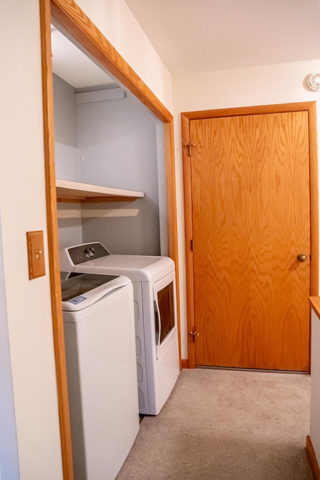 washroom featuring separate washer and dryer and light carpet