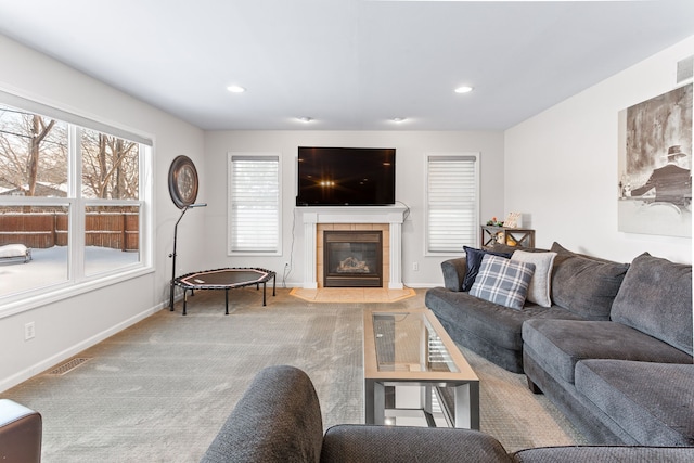 living room featuring a tile fireplace and light colored carpet