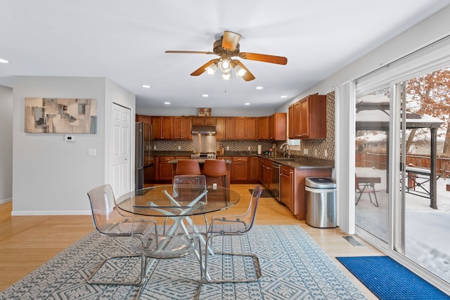 dining room with sink, ceiling fan, and light hardwood / wood-style flooring