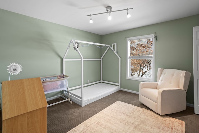 bedroom featuring track lighting and dark colored carpet