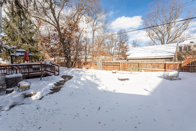 yard layered in snow with a deck