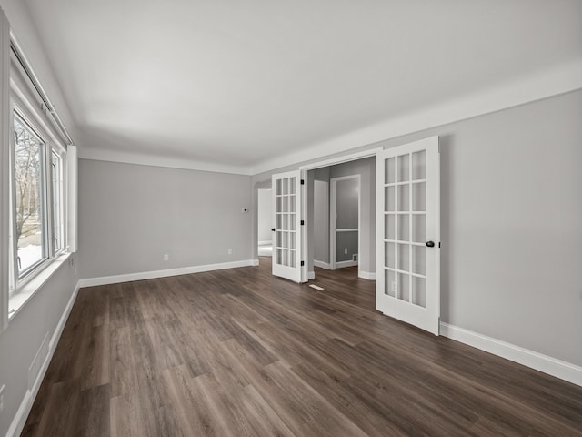 spare room with dark hardwood / wood-style flooring and french doors