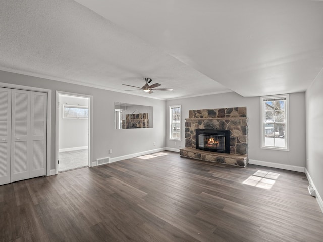 unfurnished living room featuring a fireplace, ornamental molding, dark hardwood / wood-style floors, and a healthy amount of sunlight