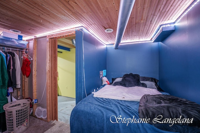 carpeted bedroom with wood ceiling and a closet