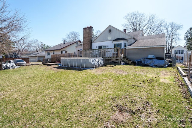 view of yard featuring fence, a fenced in pool, and a deck