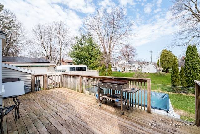 wooden terrace featuring a fenced backyard and a yard