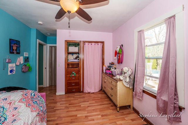 bedroom featuring ceiling fan, baseboards, and light wood-style flooring