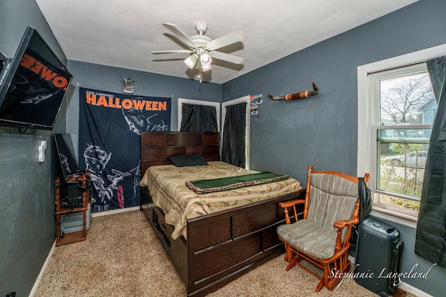 carpeted bedroom featuring baseboards and a ceiling fan