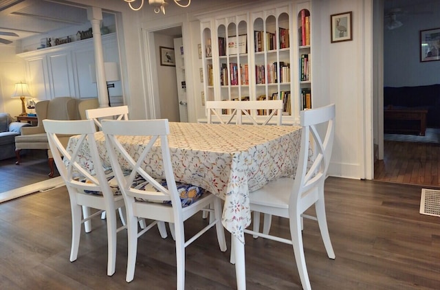 dining area with dark wood-type flooring and a chandelier