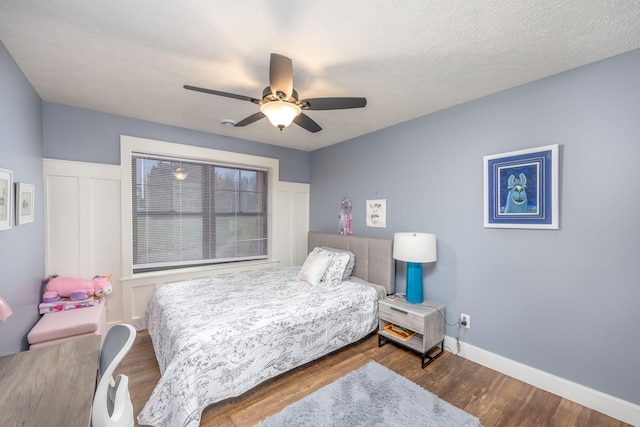 bedroom featuring hardwood / wood-style floors, a textured ceiling, and ceiling fan