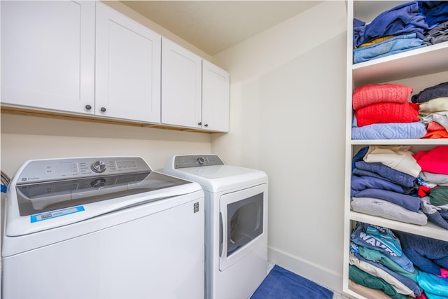 washroom with cabinets and washing machine and dryer