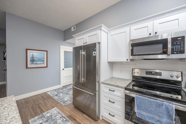 kitchen featuring white cabinets, decorative backsplash, hardwood / wood-style flooring, stainless steel appliances, and light stone countertops