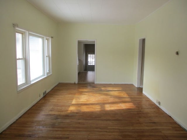 spare room featuring dark hardwood / wood-style flooring and a healthy amount of sunlight