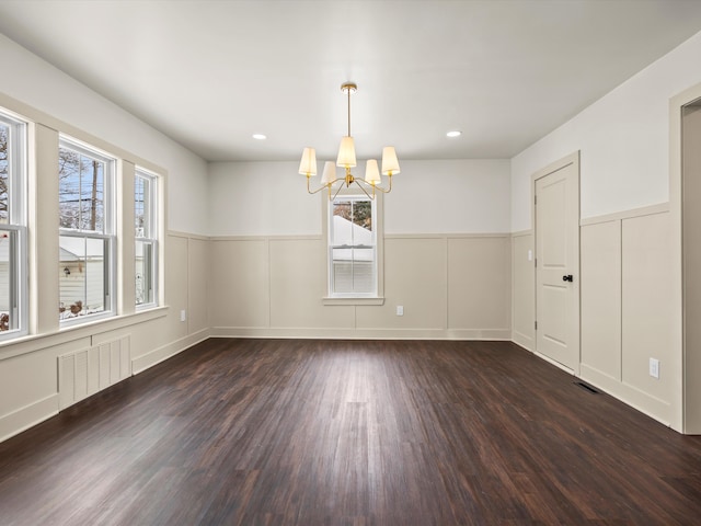 unfurnished room featuring dark wood-style floors, visible vents, and a wealth of natural light