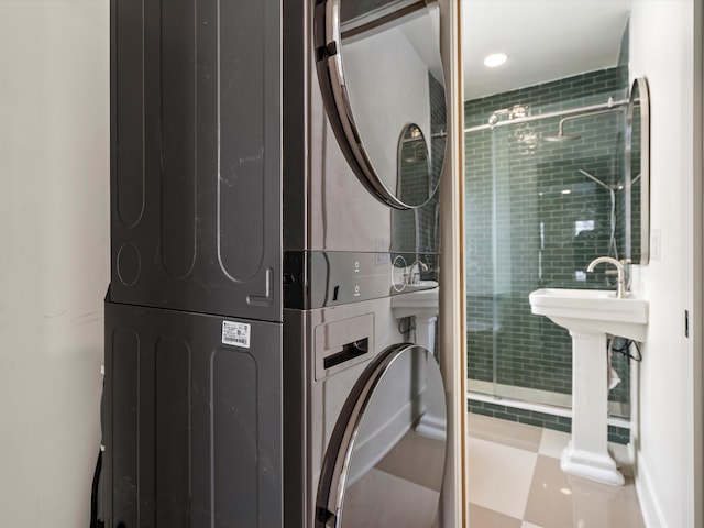 full bathroom with stacked washer and dryer and a stall shower