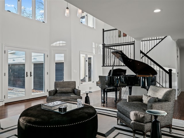 living room with french doors, recessed lighting, a high ceiling, wood finished floors, and stairs