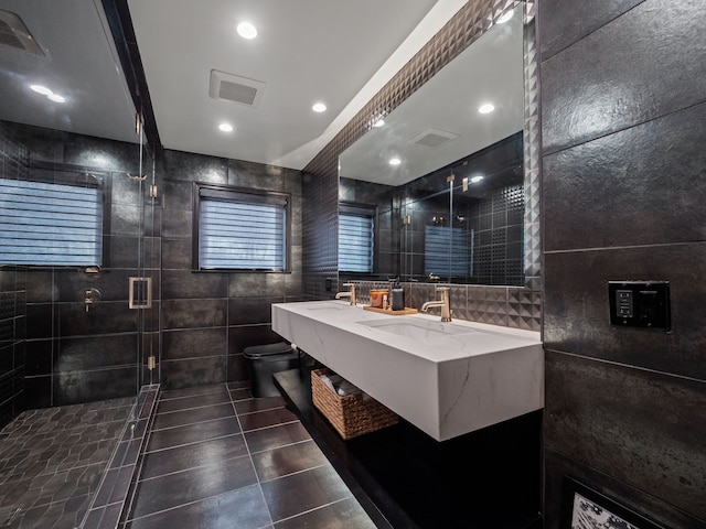 full bathroom featuring visible vents, a sink, tile walls, and toilet