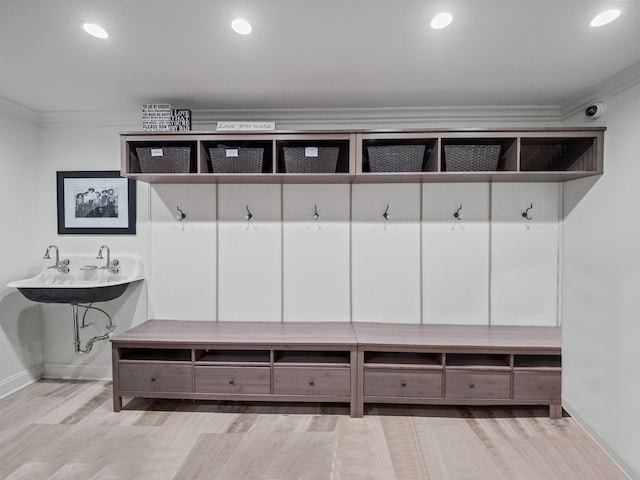 mudroom with baseboards, ornamental molding, and light wood-style floors