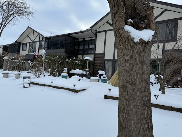 snowy yard with a sunroom