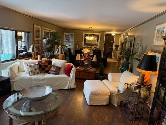 living room featuring dark wood-type flooring and ornamental molding