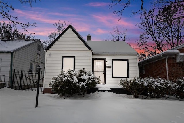 bungalow-style house featuring fence and a chimney