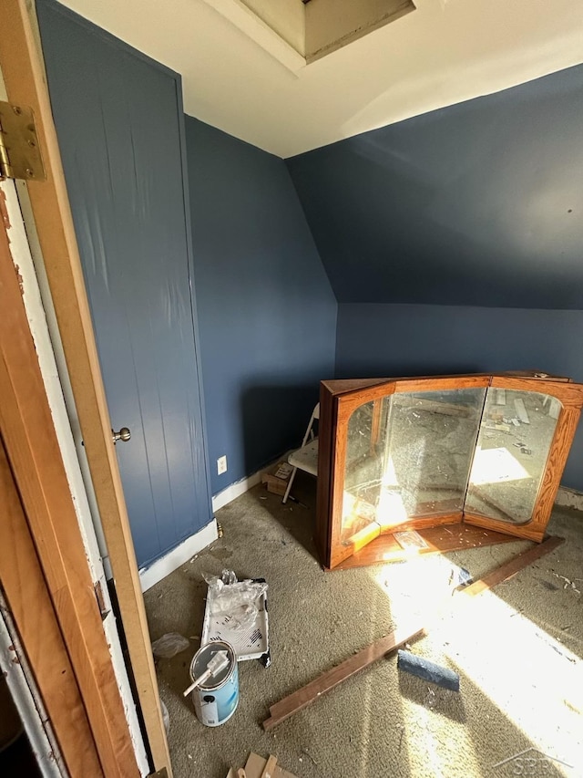 interior space featuring lofted ceiling and baseboards