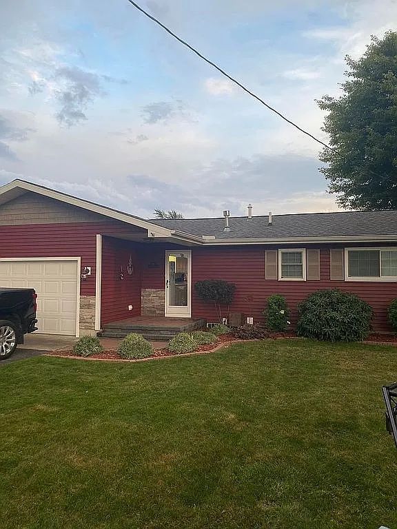 single story home featuring a garage and a front yard