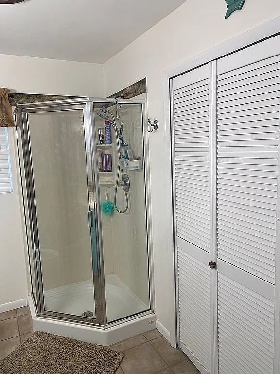 bathroom featuring tile patterned flooring and a shower with shower door