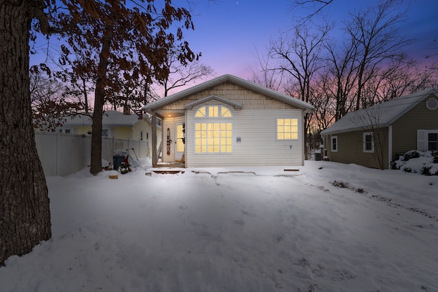 snow covered rear of property with fence