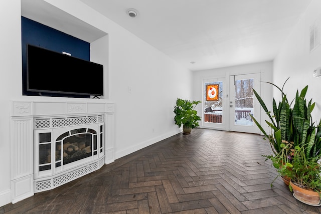 unfurnished living room featuring a tiled fireplace and baseboards