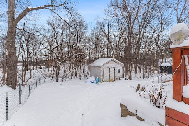 snowy yard with a storage shed