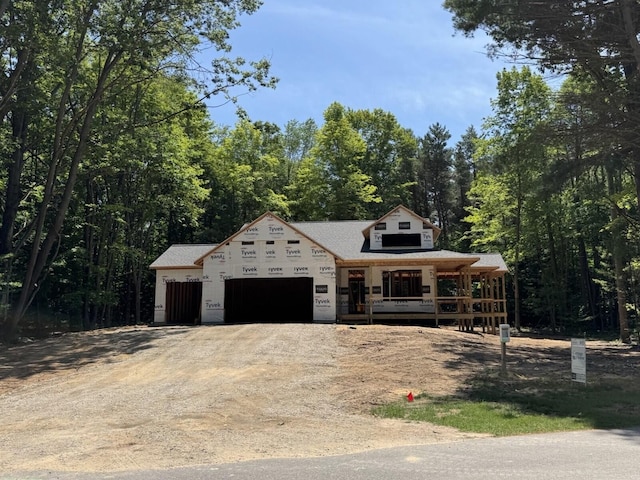 76831 Wood Crest Ct, South Haven, MI 49090 - property in mid-construction with dirt driveway, a porch, a garage, and a view of trees