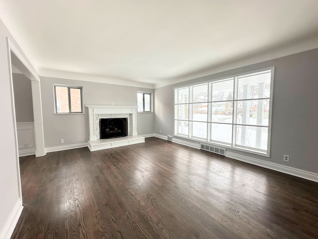 unfurnished living room with a premium fireplace and dark wood-type flooring