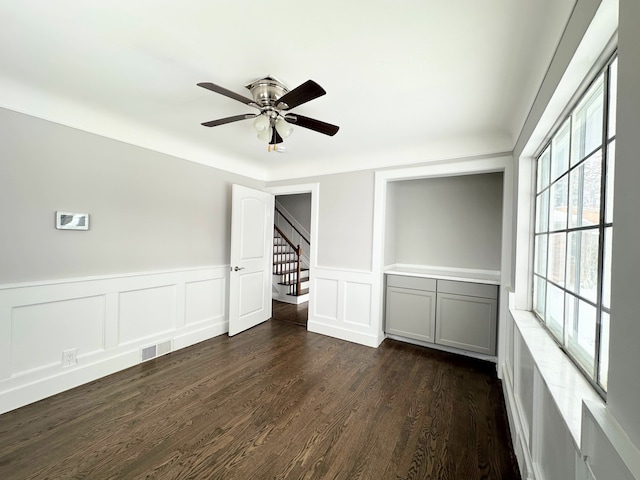 unfurnished room with ceiling fan and dark hardwood / wood-style flooring