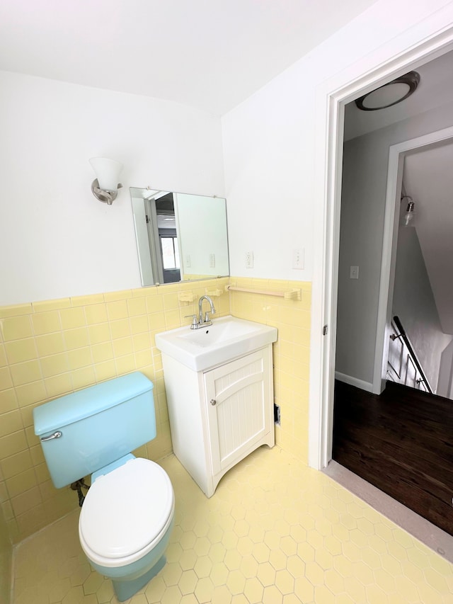 bathroom featuring tile patterned floors, toilet, tile walls, and vanity