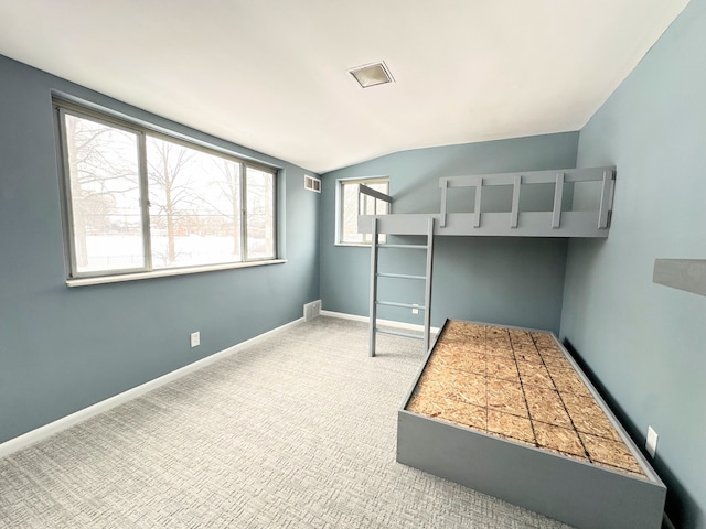 unfurnished bedroom featuring carpet and vaulted ceiling