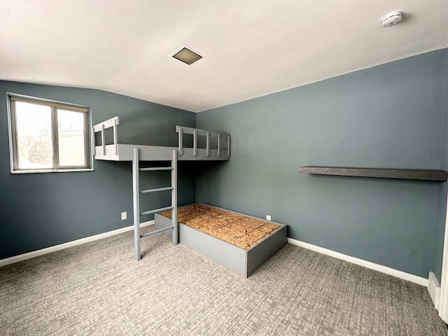 unfurnished bedroom featuring carpet and lofted ceiling