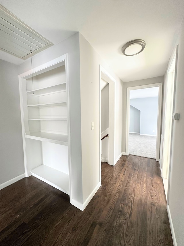 hallway with dark hardwood / wood-style flooring and built in features