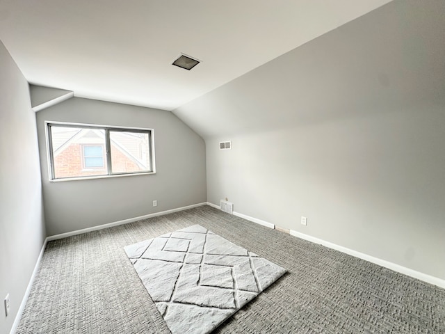 additional living space featuring vaulted ceiling and carpet