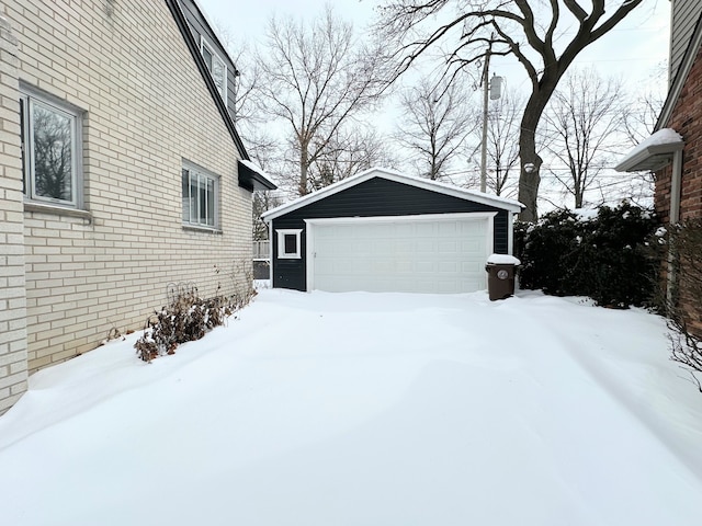 view of snow covered exterior featuring an outdoor structure and a garage