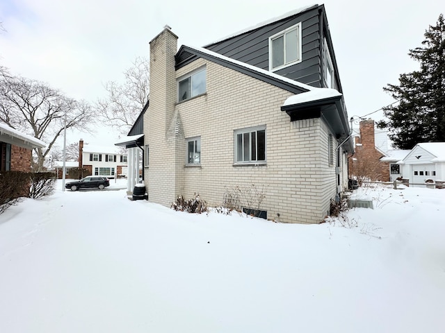 view of snow covered back of property