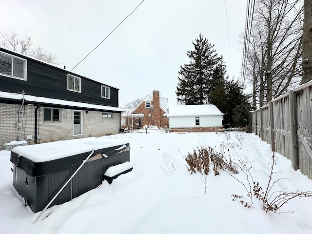 yard layered in snow featuring a hot tub