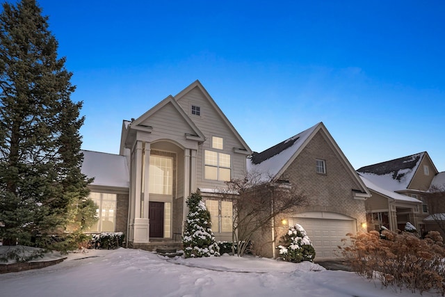 traditional-style house featuring a garage and brick siding