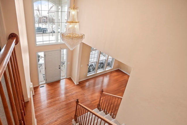 entrance foyer featuring a healthy amount of sunlight, a notable chandelier, and wood finished floors