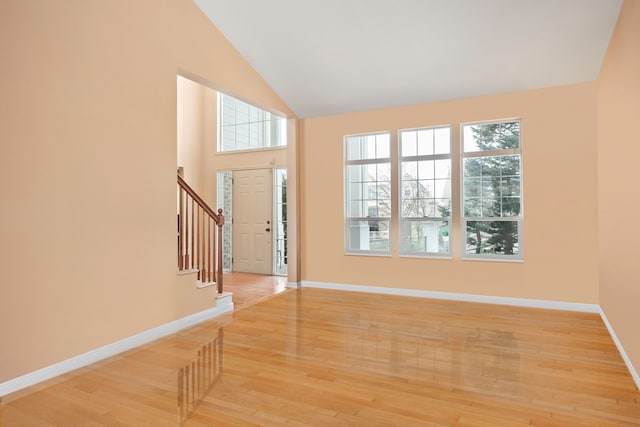 entryway featuring light wood-type flooring, stairway, baseboards, and a wealth of natural light