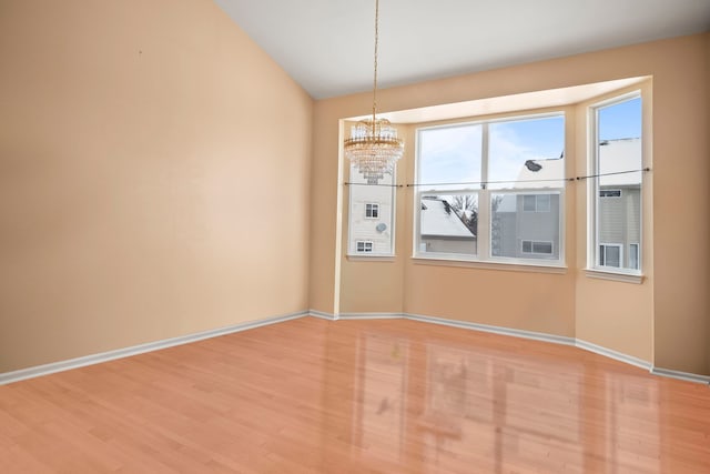 unfurnished dining area featuring light wood-style flooring, baseboards, and an inviting chandelier