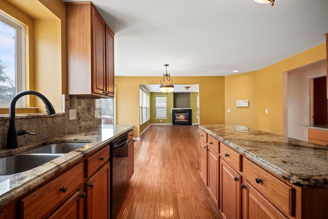 kitchen with tasteful backsplash, plenty of natural light, black dishwasher, and a sink