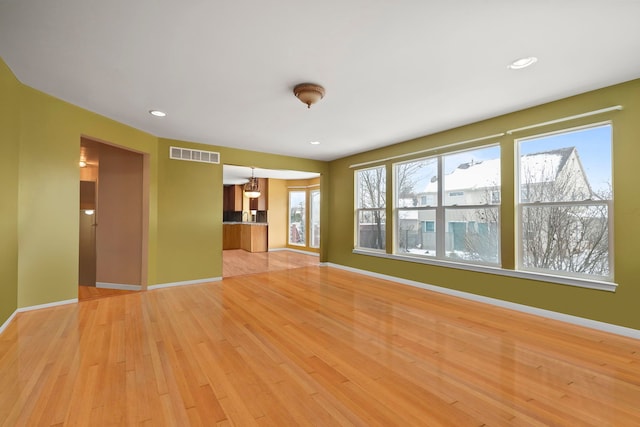 unfurnished living room featuring recessed lighting, baseboards, visible vents, and light wood finished floors