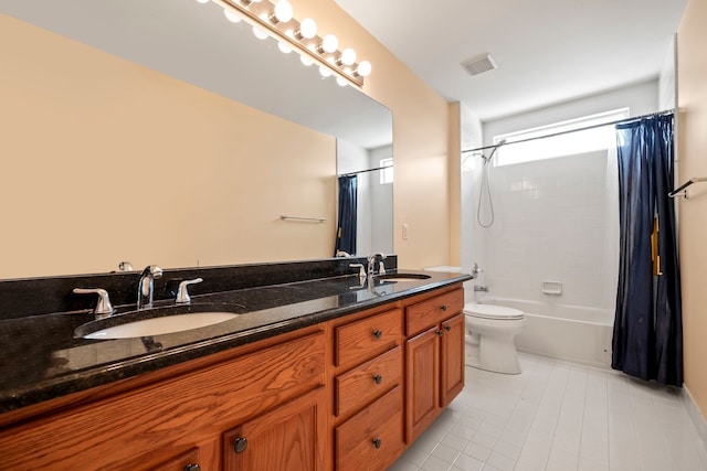 bathroom with toilet, double vanity, a sink, and visible vents