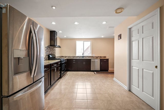 kitchen featuring dark brown cabinetry, wall chimney range hood, appliances with stainless steel finishes, and recessed lighting